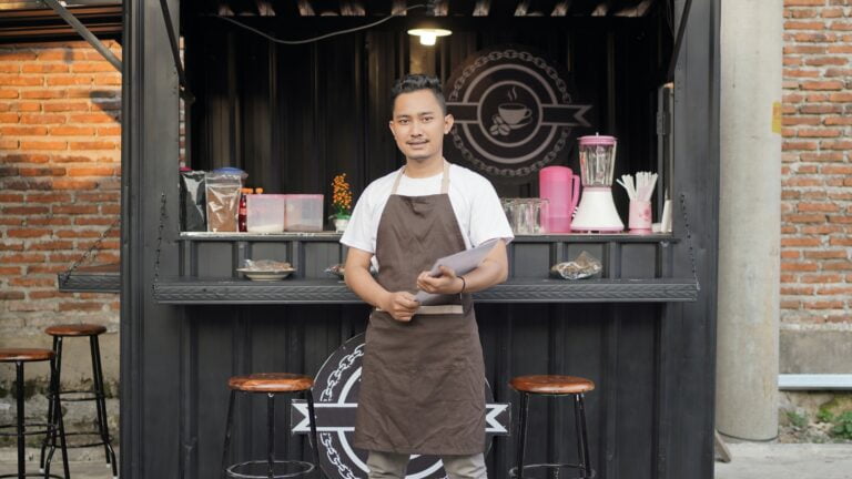 Asian man barista ready to open a container themed shop