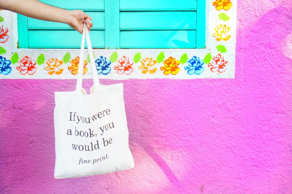 Tote bag on colorful pink background wall with traditional Mexican artwork